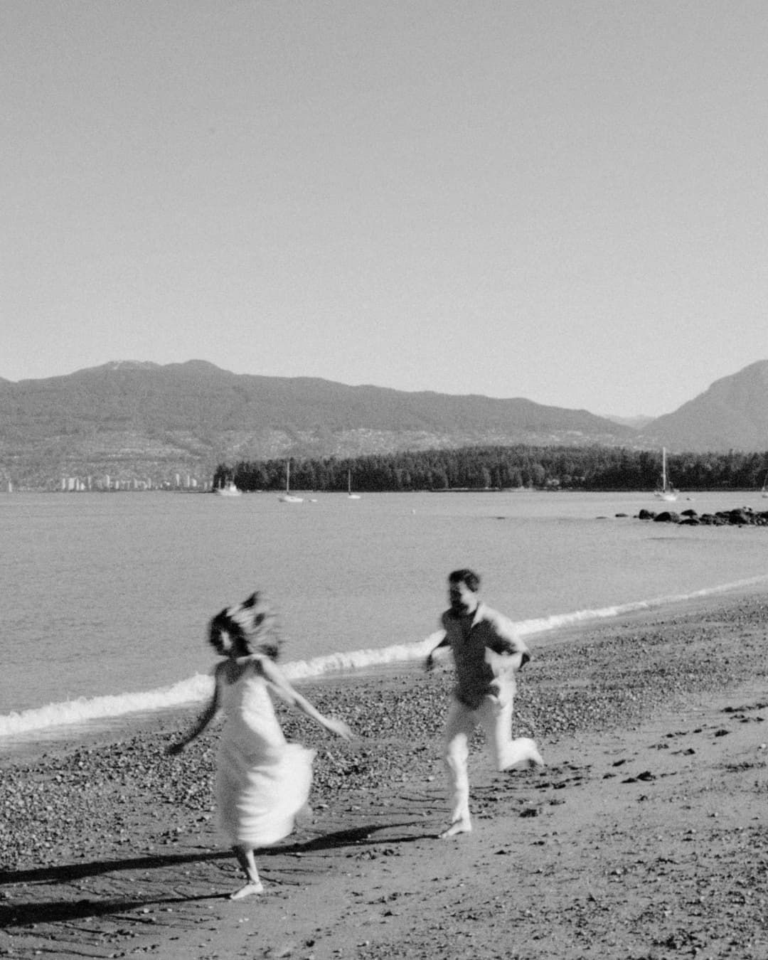 A couple running together on a calm beach at sunrise