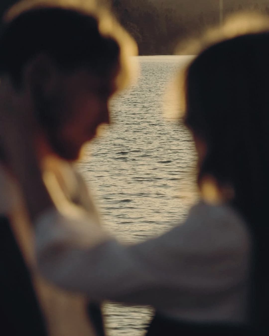 A couple embracing as the sun sets over the water
